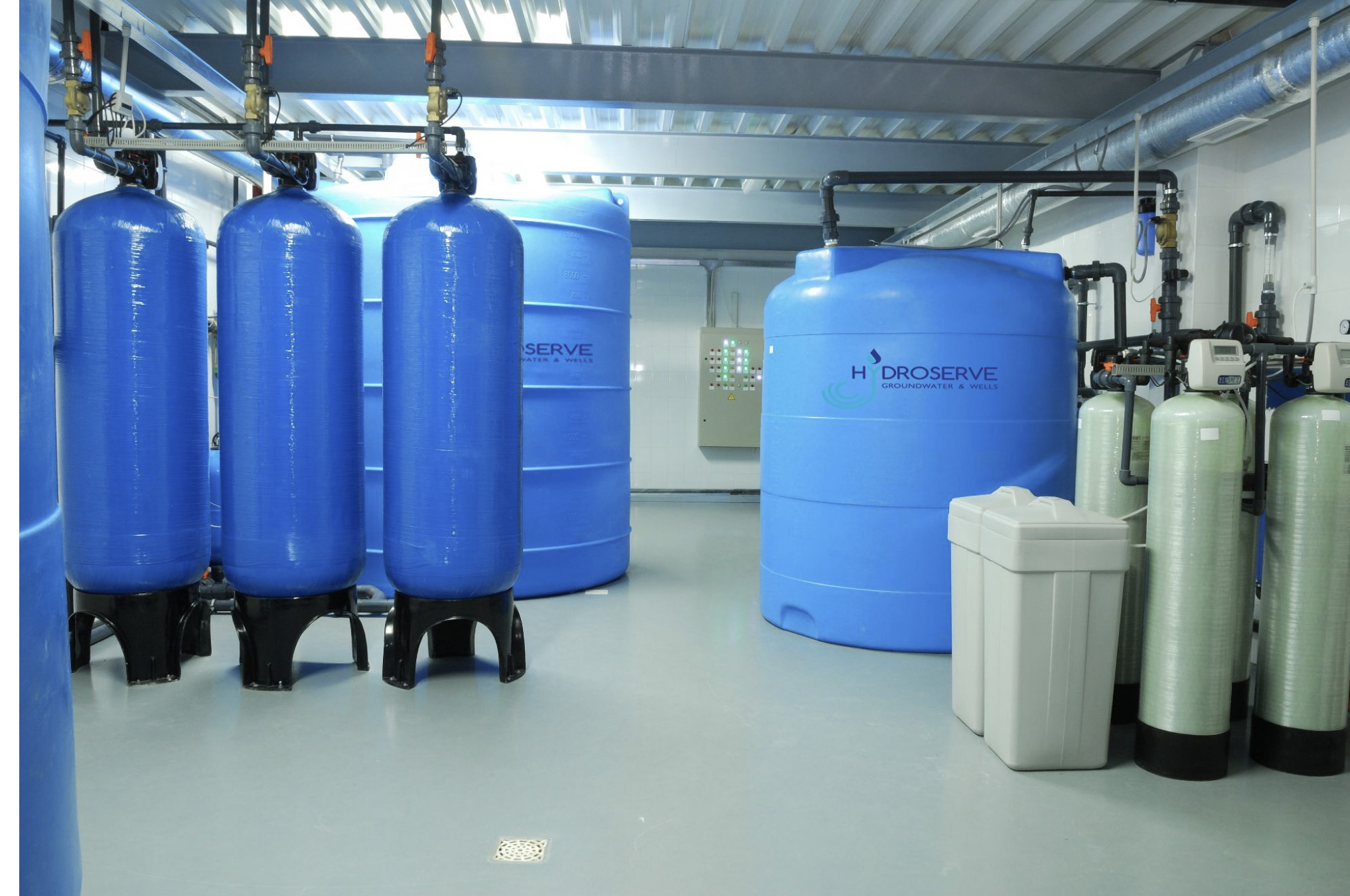 Softening and filtration systems with treated water storage tanks in a commercial factory in North East of England. Some of the tanks have the Hydroserve logo on the side.