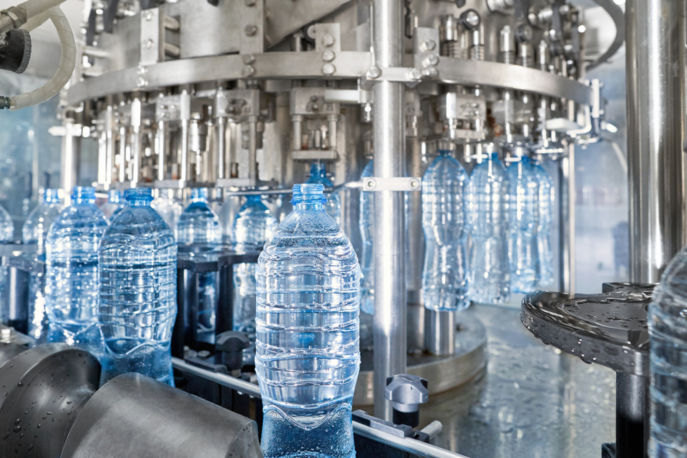 Automated line for the production of drinking water in a bottling plant. Showing bottles filled with pure water on a production line.