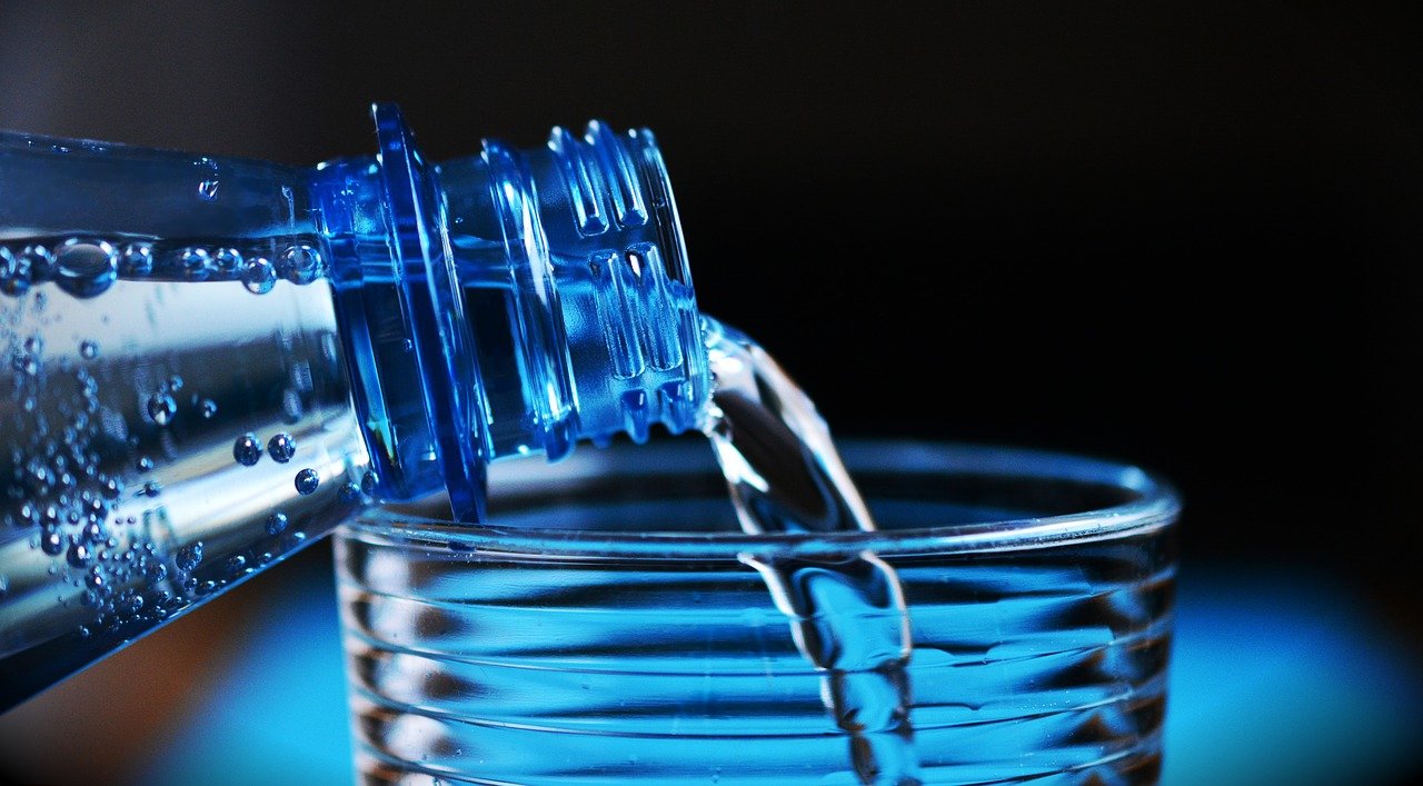 Water being poured from a bottle into a glass.